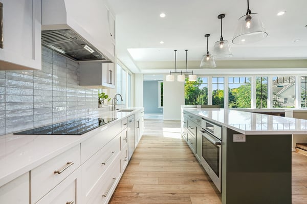 Bright kitchen with a white countertop and glass pendant lighting, part of a custom home by R Value Homes in West Michigan