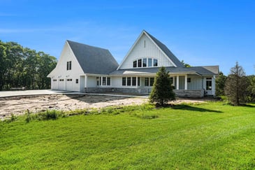 White modern farmhouse exterior with large gabled roof, built by R-Value Homes in West Michigan