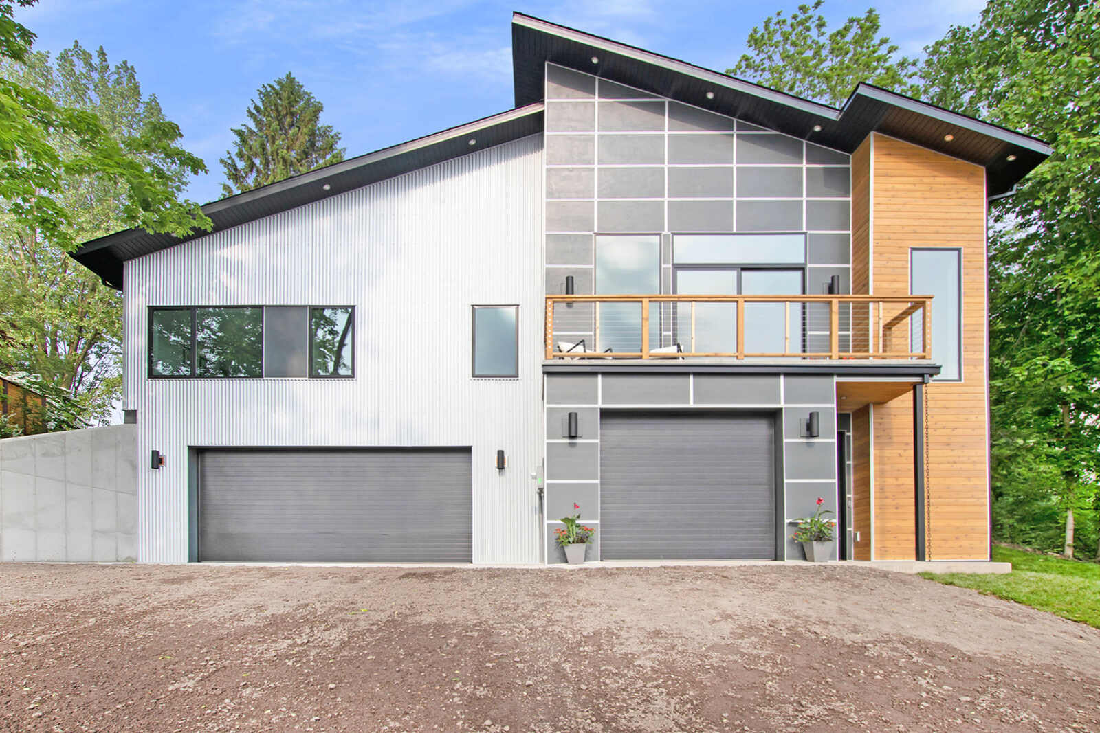 Modern custom home facade with contrasting wood and metal siding by R Value Homes in West Michigan