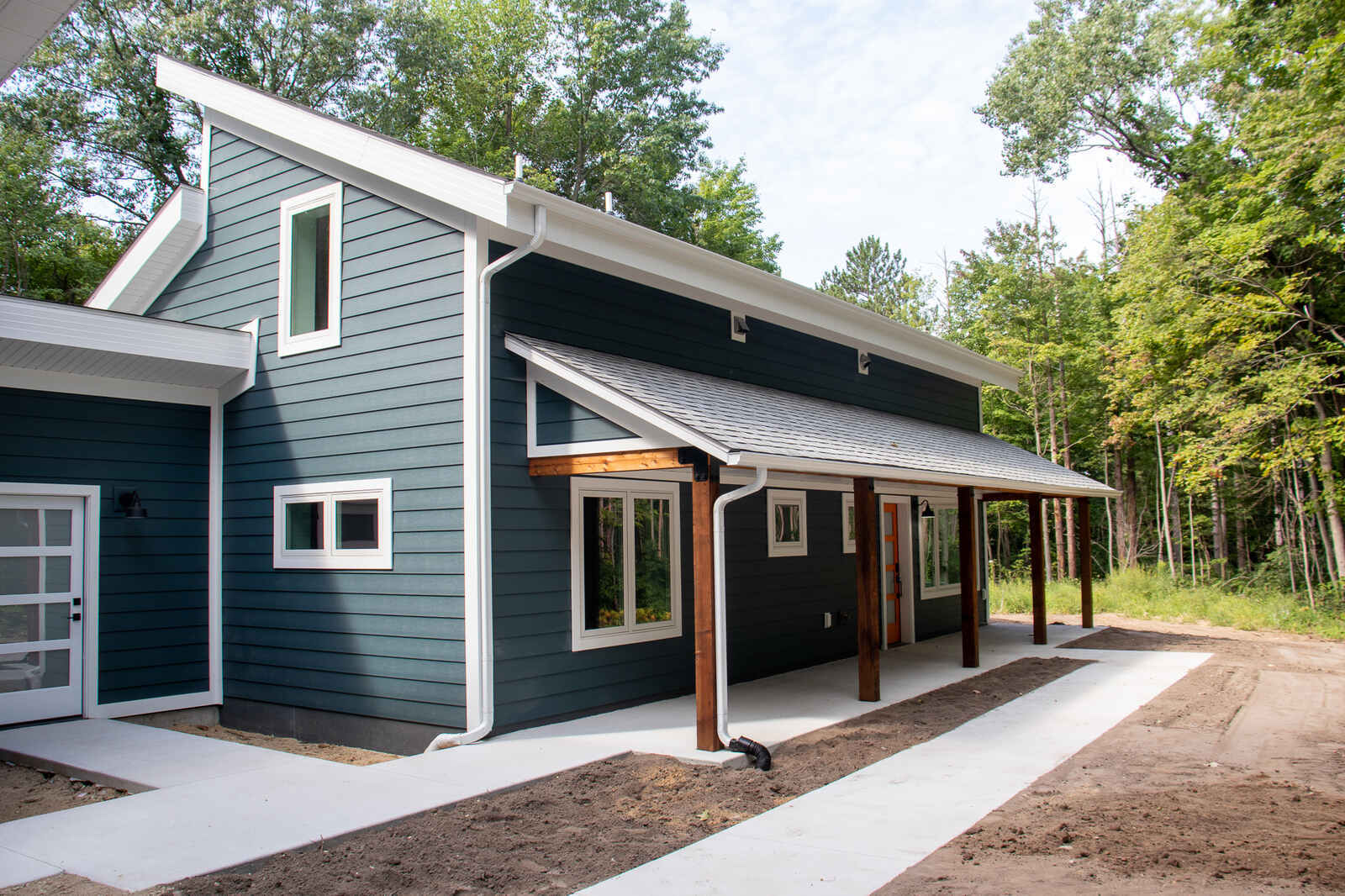 Exterior of a custom-built West Michigan home by R-Value Homes, featuring dark siding and white trim