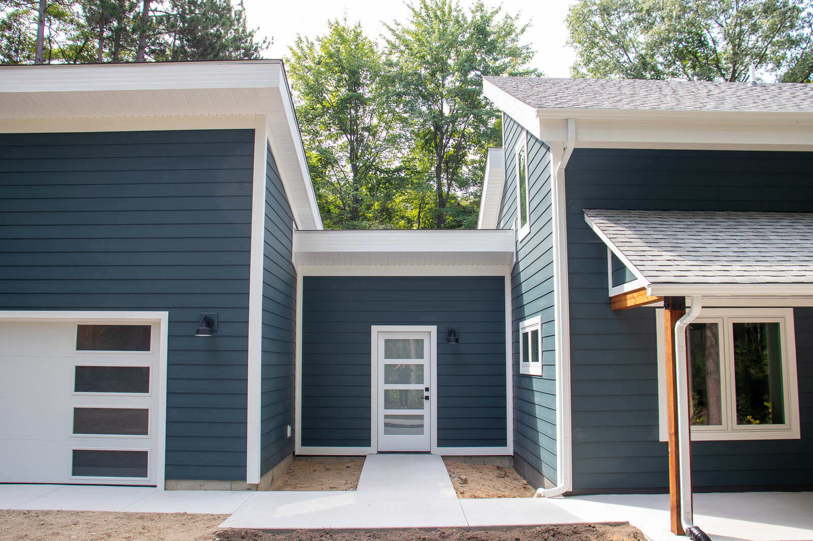 Garage entry of a custom-built West Michigan home by R-Value Homes, with sleek white doors and dark siding