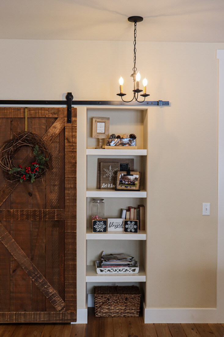 Farmhouse-style sliding barn door and built-in shelves in a custom home by R Value Homes in West Michigan