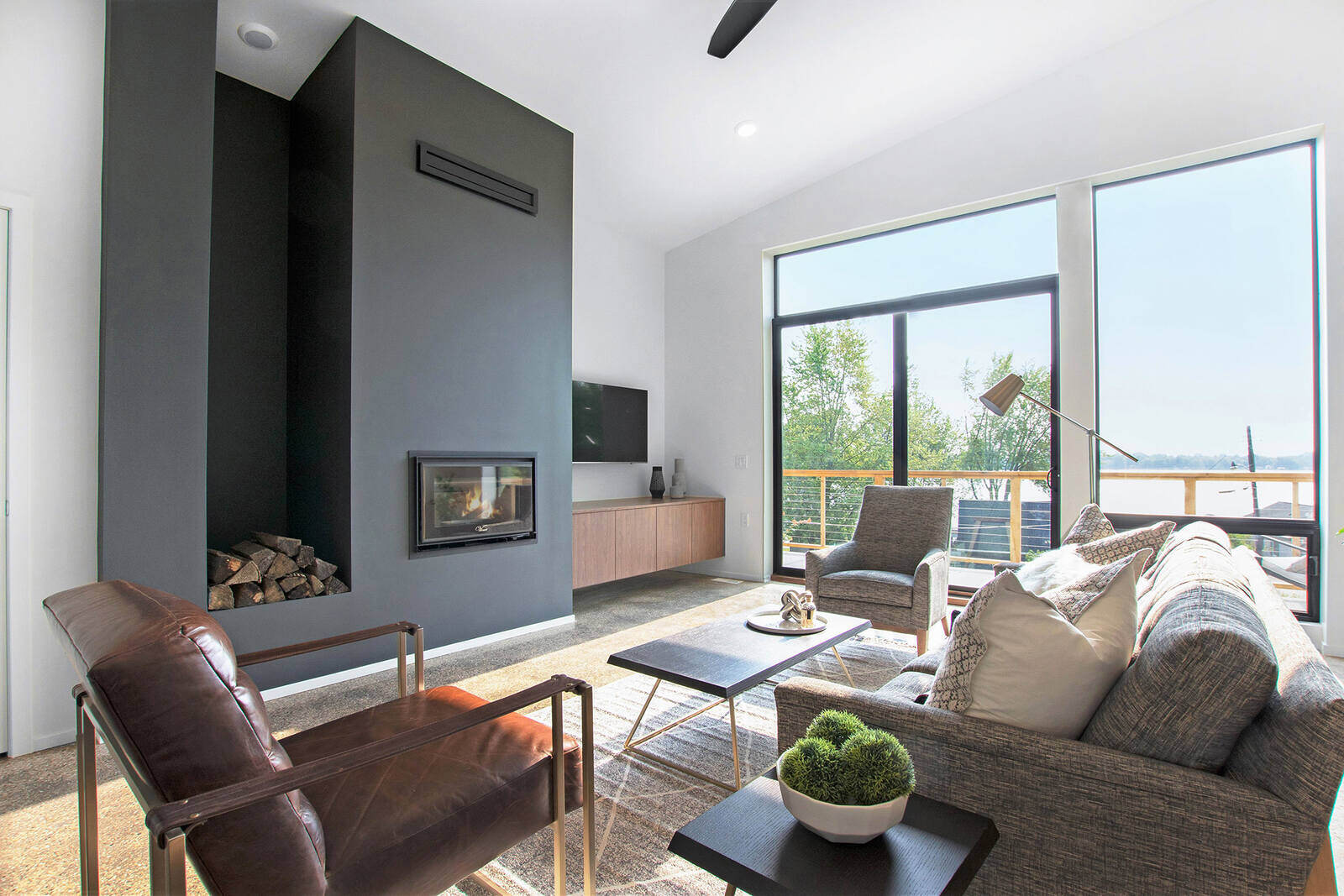 Living room with a fireplace and large windows in a custom home by R Value Homes, West Michigan