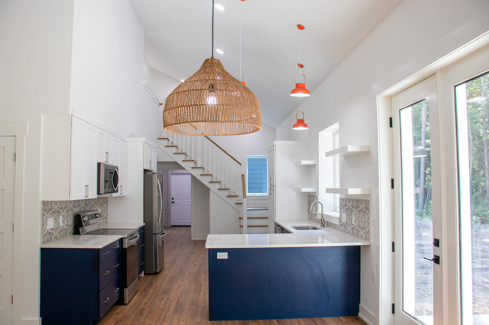 Open-concept kitchen and dining area in a custom West Michigan home by R-Value Homes, with unique pendant lighting