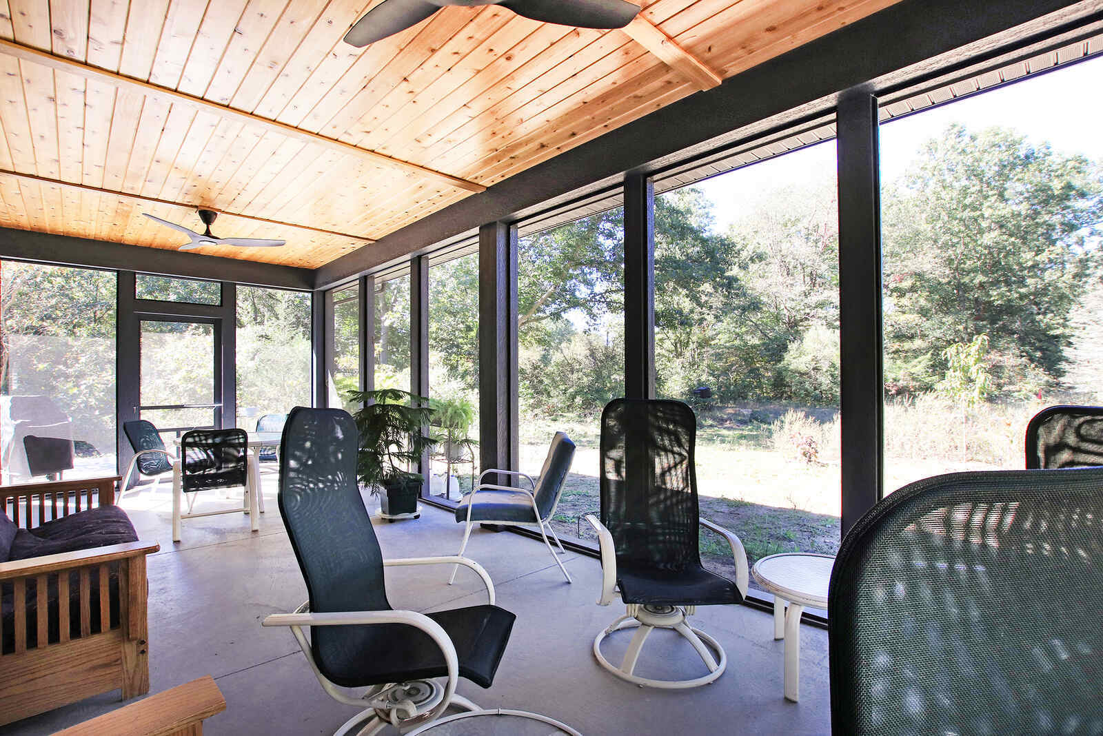 Screened-in porch with natural wood ceiling, part of a West Michigan custom home by R Value Homes